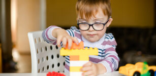 little ginger boy with glasses with syndrome dawn playing